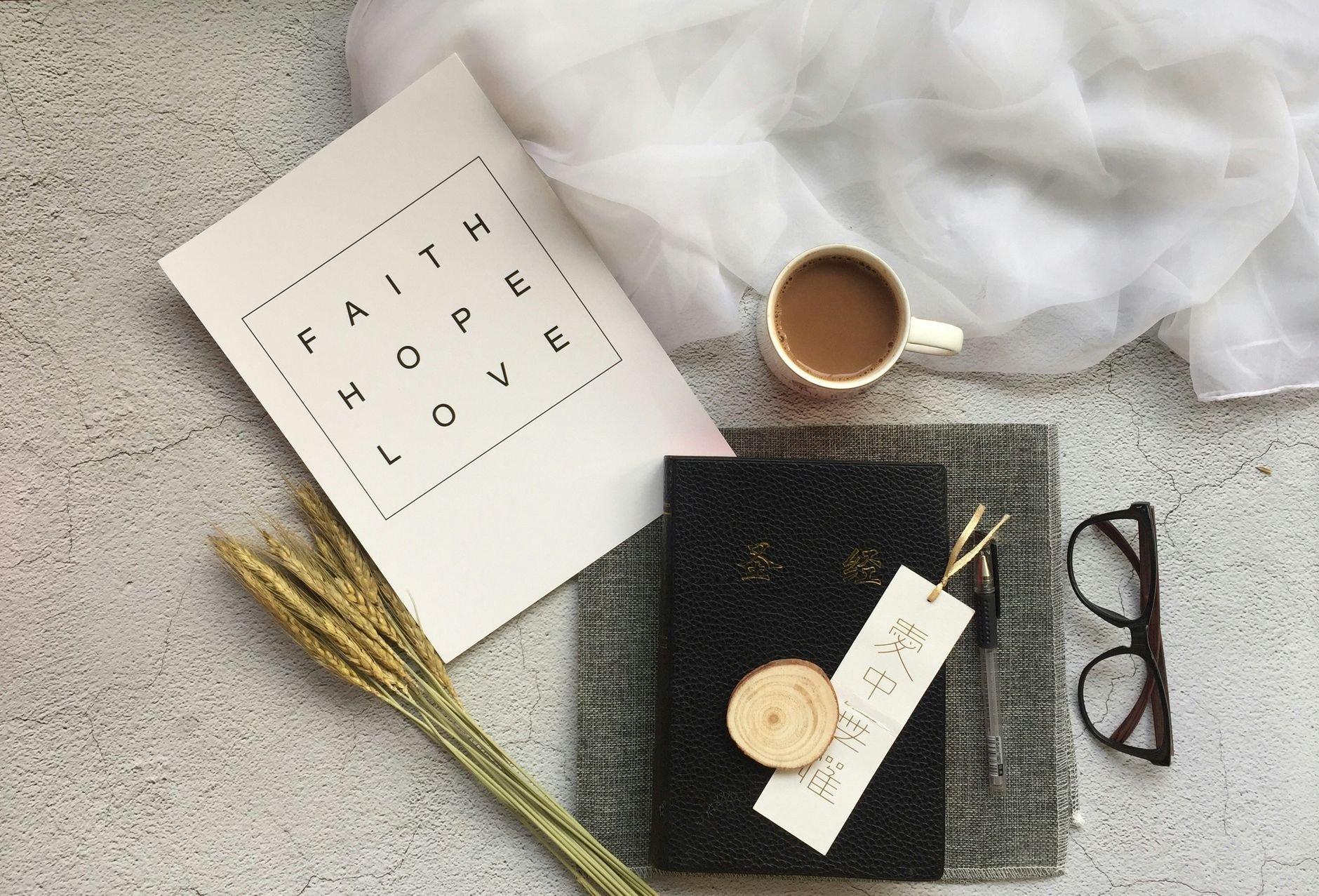 Flat lay of coffee, notebooks and inspirational text — the tools of a thoughtful creator